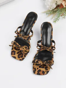 Vista macro detallada de los lazos de leopardo y el diseño de punta cuadrada de sandalias.