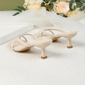 Side view detail of beige square toe kitten heel flip-flop sandals with elegant thin straps