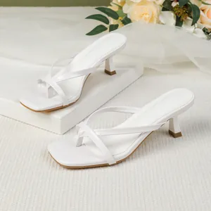Detailed view of white square-toe thong sandals with elegant stiletto kitten heels