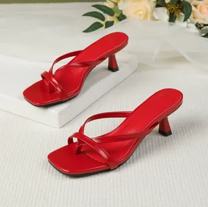 Elegant red square-toe thong heeled sandals with crisscross straps shown in detail
