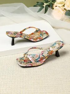 Detail view of floral print thong sandals with kitten heel and elegant square toe design.