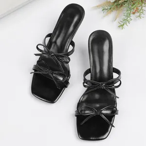 Elegantes sandalias negras de tacón alto con lazos múltiples y punta cuadrada de moda.