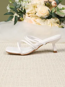 Zijaanzicht detail van witte Franse muiltjes met kittenhak en elegante dunne bandjes