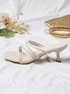 Detailopname van elegante beige sandaaltjes met bandjes en een moderne vierkante neus.