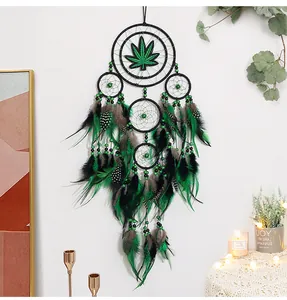 Detalle de un atrapasueños artesanal en verde y negro con diseño de hoja de arce.