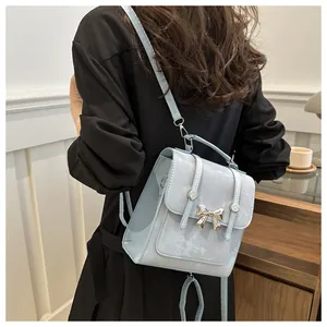 Rückansicht eines kleinen hellblauen Rucksacks mit einer Metallschleife an der Schulter