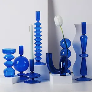 Collection de vases et bougeoirs en verre bleu cobalt sur socles blancs au design moderne