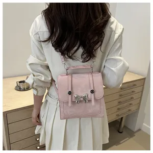 Detailansicht eines kleinen rosa Rucksacks mit silberner Schleife an einem weiblichen Model