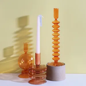 Bougeoirs artistiques en verre orange aux designs nervurés et sphériques esthétiques uniques.