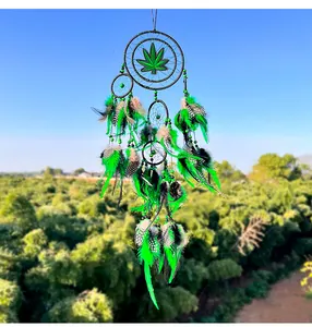Vista detallada del atrapasueños hecho a mano con hoja verde y plumas naturales