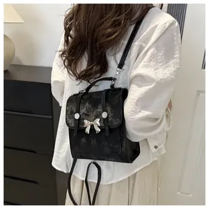 Schicker kleiner schwarzer Rucksack mit silberner Schleife und strukturierter Optik.