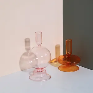 Gros plan de bougeoirs artistiques en verre rose et ambre pour la décoration de table