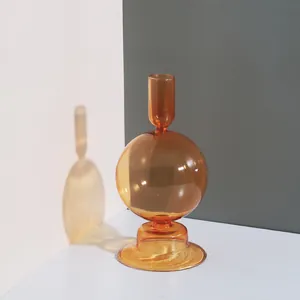 Gros plan artistique d'un bougeoir en verre ambré avec ombre et corps sphérique