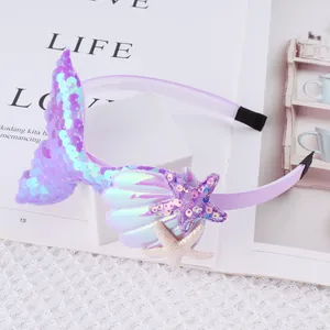 Detail view of sequin mermaid tail headband with glittery sea star and shell.