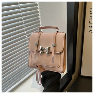 Detailansicht eines rosafarbenen Wildleder-Rucksacks für Damen mit schicker Metallschleife