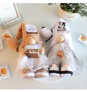 Detailed view of two plush standing gnome dolls with bread and cow themes for home decor.