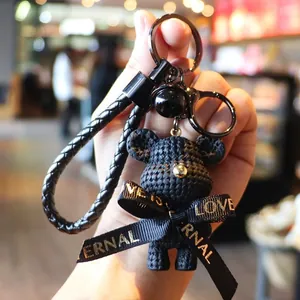 Cute black woven bear keychain charm with braided strap and elegant ribbon bow