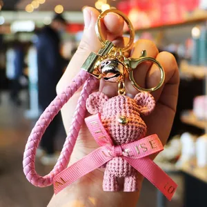 Adorable pink resin bear keychain accessory featuring a braided strap and golden bell