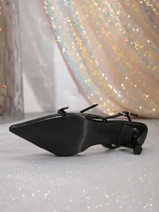 Close-up detail of black pointed-toe slingback heels showing the stiletto and sole