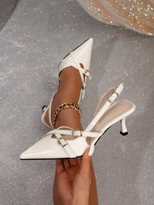 Close-up of white pointed toe kitten heels with double buckle straps and slingback design