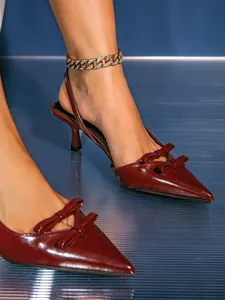 Detailed view of elegant burgundy double bow slingback kitten heels on model feet
