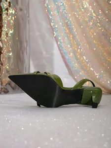 Green pointed toe kitten heel with double straps and backstrap on shimmering background