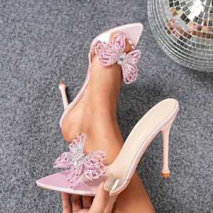 Close-up of pink pointed-toe PVC heels featuring a sparkling rhinestone butterfly ornament.