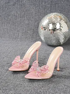 Side view of pink transparent PVC high heels with rhinestone butterfly decor and disco ball