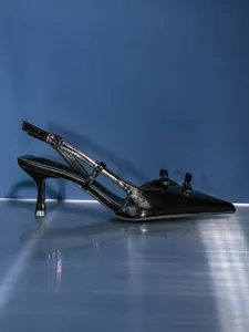 Elegant side profile of black pointed-toe slingback heels featuring double bow detail