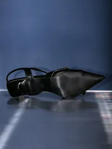 Primo piano della suola antiscivolo e del tacco basso di una scarpa nera a punta elegante