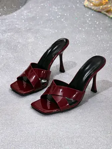 Close-up of wine red patent leather high heel sandals with cross straps