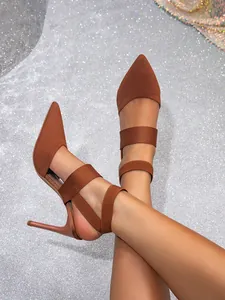 Close-up view of brown knitted pointed-toe stiletto high heels on feet with straps