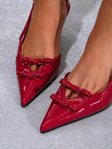 Close-up of elegant wine red patent leather pointed toe heels with double bow detail
