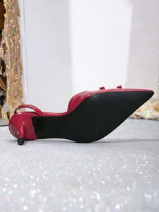 Detailed bottom view of elegant red pointed-toe slingback pumps with thin high heels
