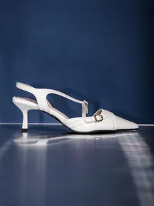 Eleganti sandali bianchi slingback con tacco a gattino e fibbia su sfondo blu scuro