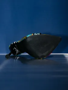 Close-up view showing the anti-slip black sole and sleek stiletto heel of colorful snakeskin sandals.