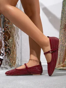 Detailansicht von weinroten, perforierten Mary-Jane-Flachschuhen an einem Modell.