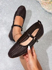 Nahaufnahme eleganter schwarzer Mary Jane Ballerinas mit Lochmuster und Schnallenriemen