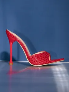 Close-up detail of red snake-embossed stiletto mule with peep toe design
