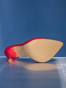 Detailed macro view of red snake-pattern high heel sandal sole and stiletto heel tip