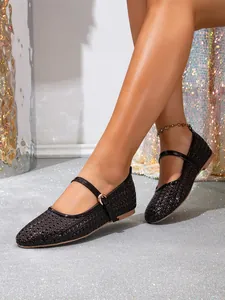 Detail der schwarzen geflochtenen Mary Jane Ballerinas mit goldener Schnalle.