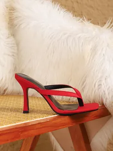 Detailweergave van elegante rode sandalen met hoge hakken en een verfijnd ontwerp
