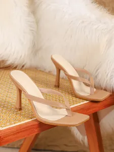 Gedetailleerd zijaanzicht van beige sandalen met hoge hakken en een stijlvolle vierkante neus