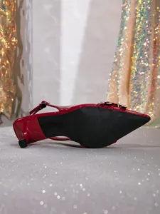 Vista detallada de un zapato kitten heel de charol rojo con suela negra antideslizante.