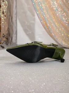 Detalle de zapatos de salón verdes vintage con punta afilada y correa trasera con hebilla