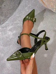 Primer plano de elegantes tacones en punta verde oscuro con hebilla y tira trasera