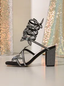 Sandales à talons carrés noirs avec brides papillon en strass