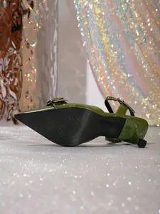 Vista detallada de la suela negra antideslizante de zapatos de tacón verde brillo
