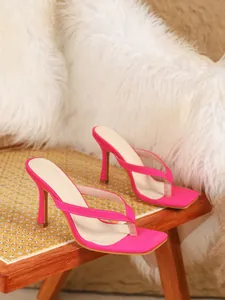Elegante fuchsia high heel teenslippers in Franse stijl op een chique rotan stoel