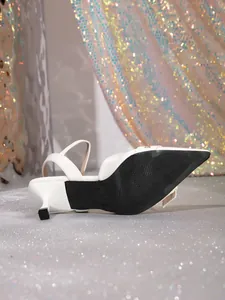 Vista detallada de zapatos slingback blancos en punta con suela antideslizante
